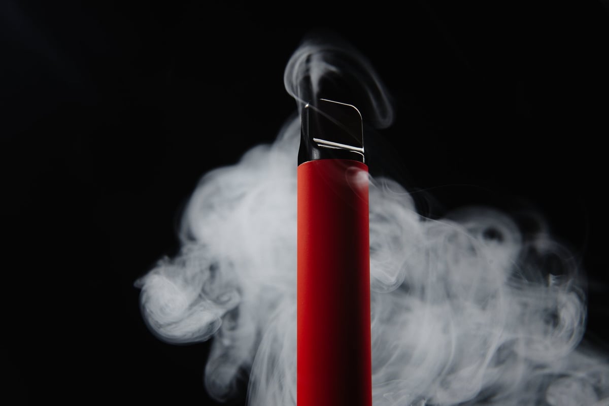 Colourful disposable vape device on a dark background