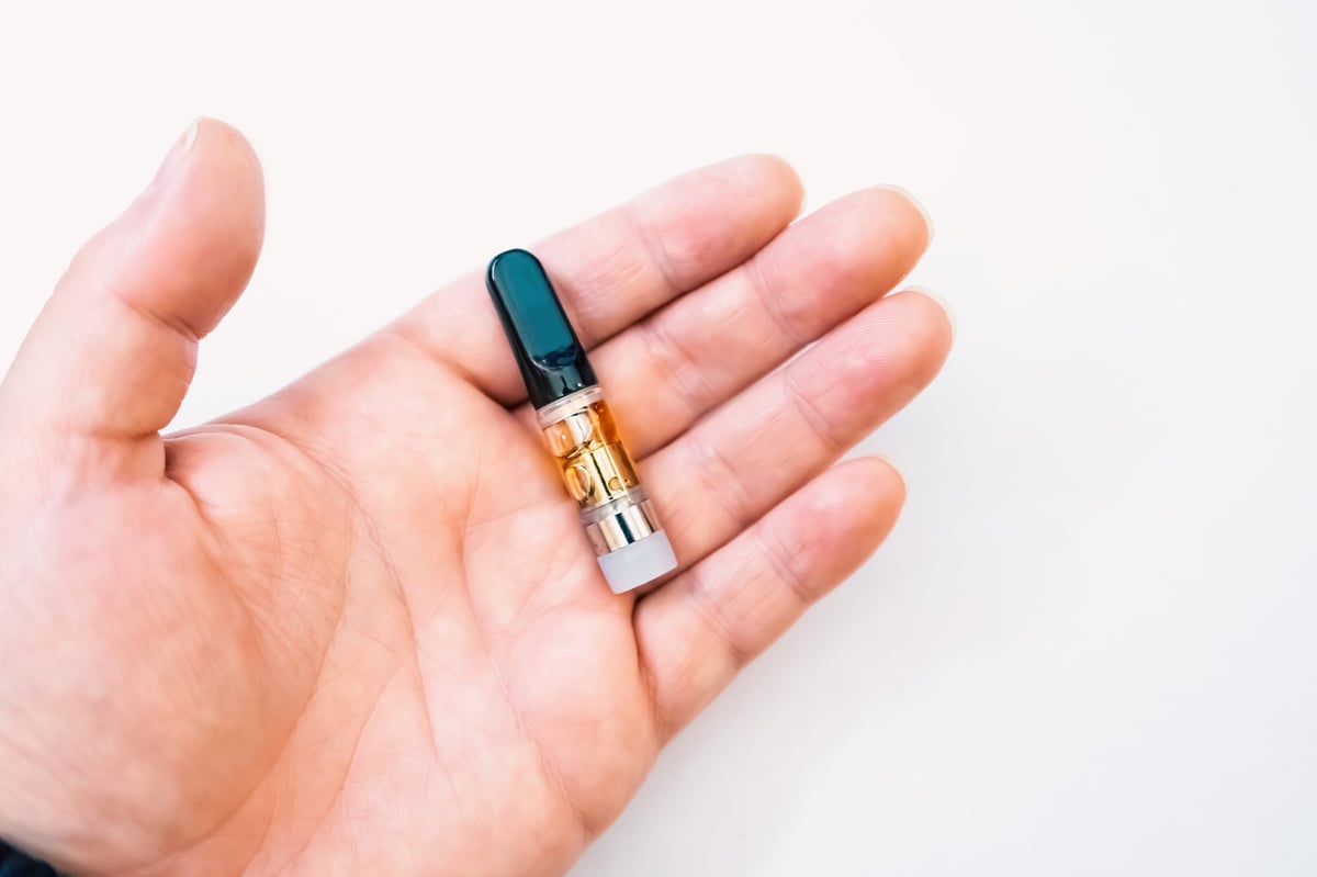 Live resin cannabis cartridge held in hand