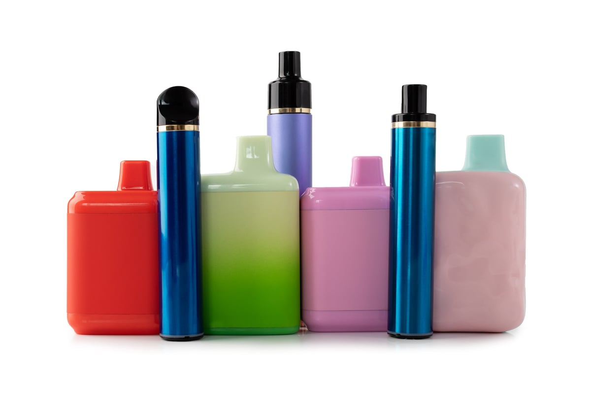 Multicoloured disposable vape devices arranged on a white background