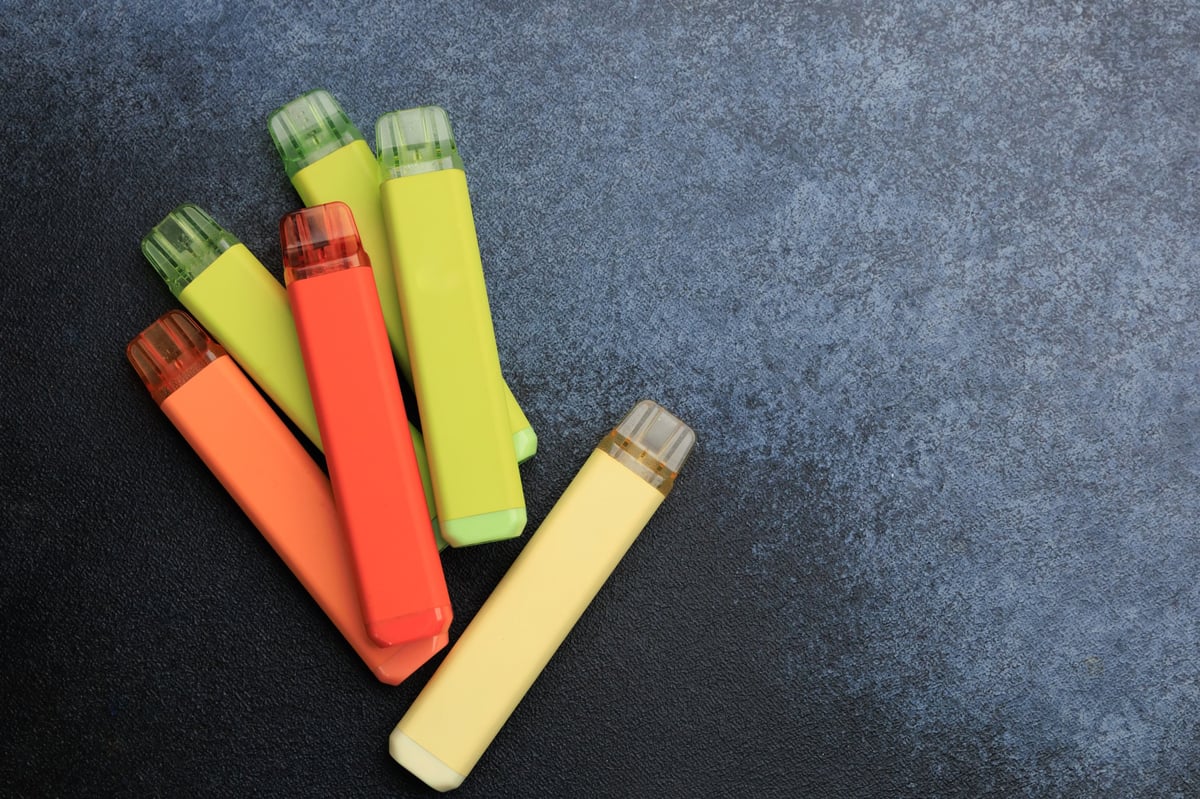 Collection of disposable vape devices grouped on a flat surface