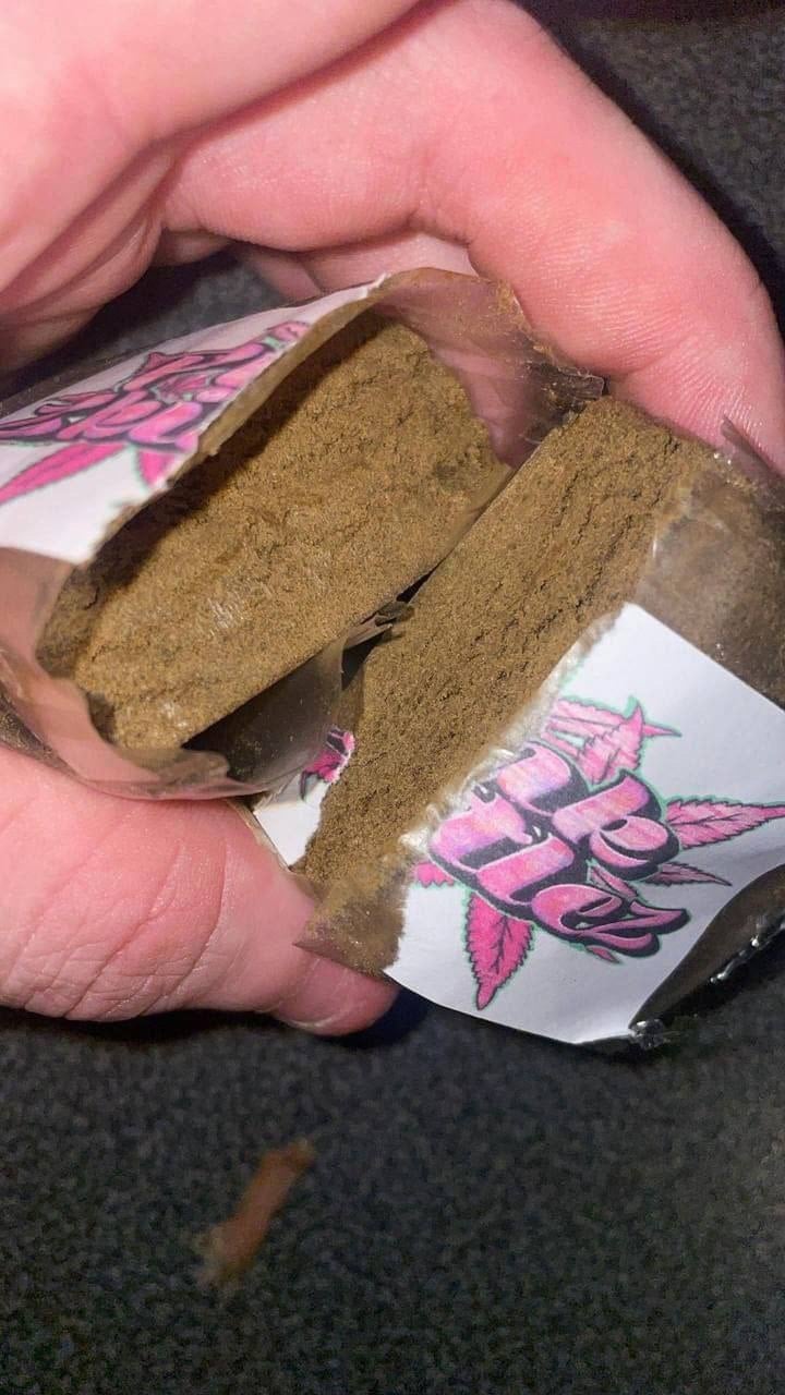 Moroccan hash close-up held between the fingers, showing richness of colour