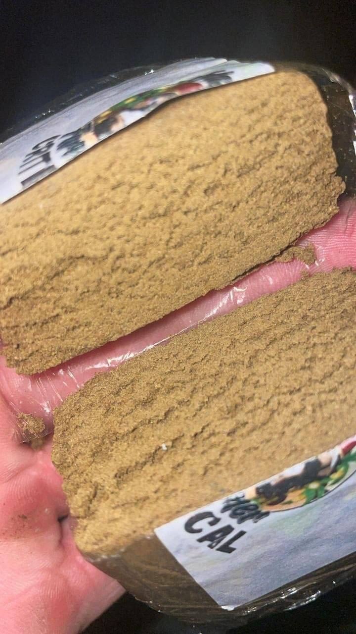 Gold Rush Moroccan hash photographed in hand, showing the golden-brown pressed texture
