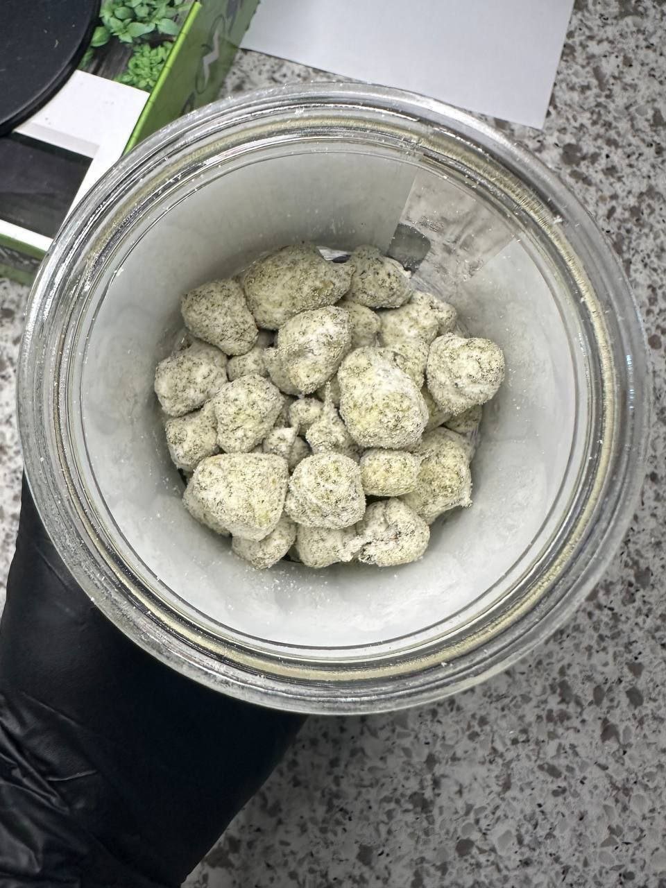 Overhead view into an open jar of Snow Ball Moonrocks, the round balls thickly coated in pale green frosting