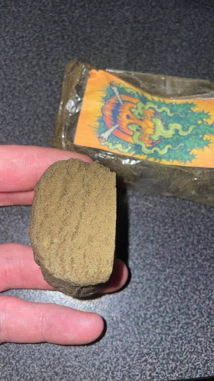 Pressed portion of Gold Rush Moroccan hash held up to show the bar