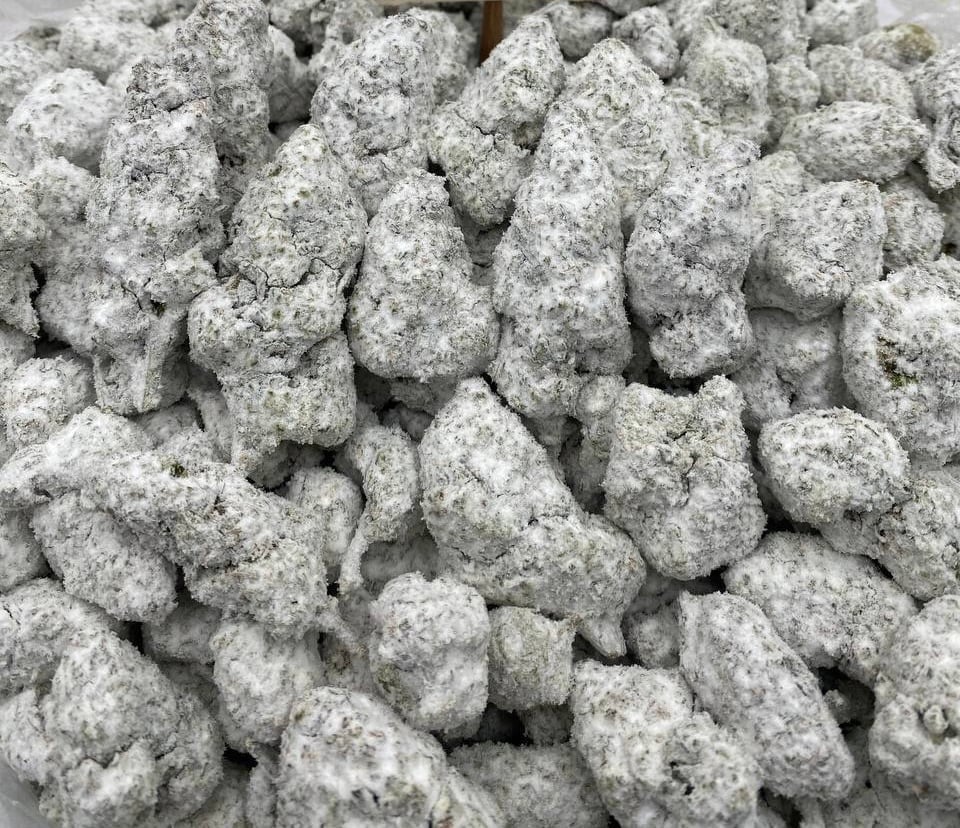Close-up of Strawberry Freeze snowcaps piled together, buds evenly coated in a pale frosted layer